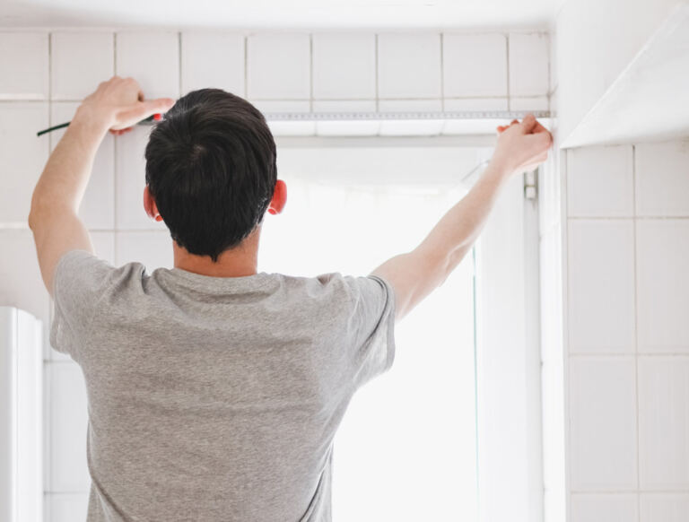 A Step-by-Step Guide on How to Install Roller Blinds - man measuring window